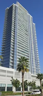 a large building with palm trees in front of it at Modern Luxury Studio Damac Hills With Golf View in Dubai