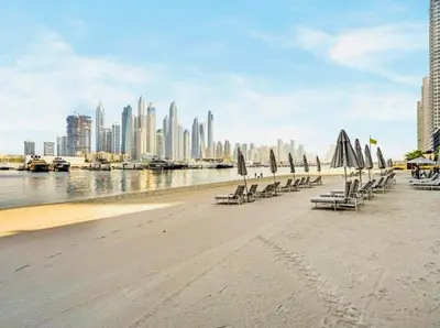 a group of beach chairs with umbrellas on the beach at Exquisite Beachfront 1BR l Palace Beach Residence in Dubai