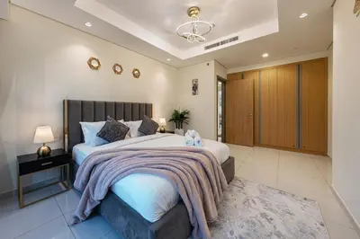 a bedroom with a large bed with a blanket at Iconic Burj Khalifa View 2BR Luxury apmt at Paramount Midtown in Dubai