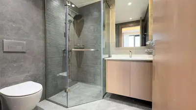 a bathroom with a shower and a toilet and a sink at Werova - Modern 1BR Apartment Prime JVT Location in Dubai