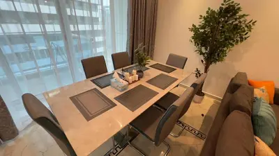 a dining room table with chairs and a potted plant at Dubai Marina Apartment Steps to DMCC Metro & JBR in Dubai