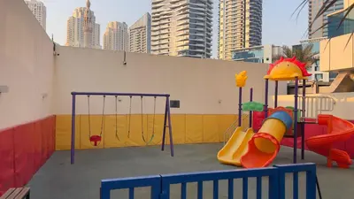 a playground with a slide and a swing set at Dubai Marina Apartment Steps to DMCC Metro & JBR in Dubai