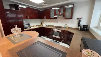 a kitchen with wooden cabinets and a counter top at Dubai Marina Apartment Steps to DMCC Metro & JBR in Dubai