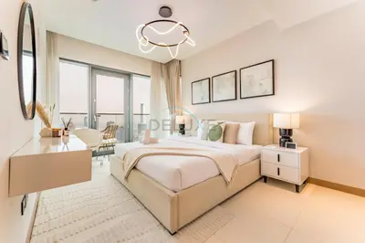 a bedroom with a large bed and a table and chairs at Prime Location with Direct Mall and Marina Walk Access, Just Outside DMCC Metro Station - VIDA Residences, Dubai Marina by Deluxe Holiday Homes in Dubai