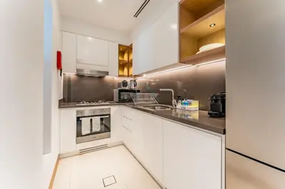 a kitchen with white cabinets and stainless steel appliances at Prime Location with Direct Mall and Marina Walk Access, Just Outside DMCC Metro Station - VIDA Residences, Dubai Marina by Deluxe Holiday Homes in Dubai