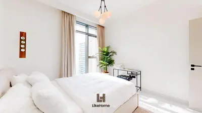 a white living room with a couch and a window at Stunning 2BR Beachfront Living Marina Vista Tower 2 in Dubai