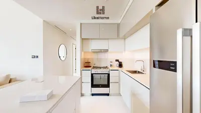 a white kitchen with white counters and appliances at Stunning 2BR Beachfront Living Marina Vista Tower 2 in Dubai