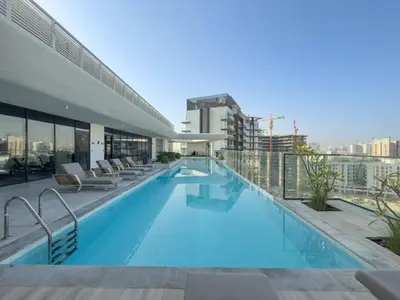 a swimming pool on the roof of a building at Chic Pool-View Studio Oxford Gardens by Czechin in Dubai