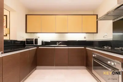 a kitchen with wooden cabinets and a sink at Spacious Beachfront 2BR with Maids Room in Grandeur in Dubai