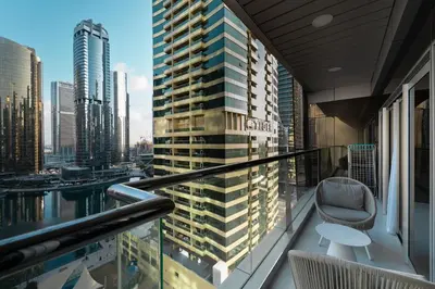 a balcony with a chair and a view of a city at Escape 24 Spacious 1BR Lake View, Global Lake View, JLT in Dubai