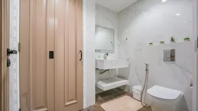 a white bathroom with a toilet and a sink at Contemporary one-bedroom apartment in Burj Khalifa area by Norbu Holiday Homes in Dubai