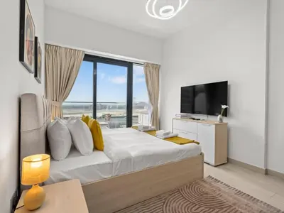 a bedroom with a large bed with a large window at The Comfort Cove Studio in Azizi Riviera 32 in Dubai
