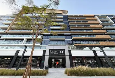 a tall building with a tree in front of it at The Comfort Cove Studio in Azizi Riviera 32 in Dubai