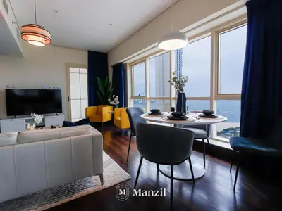 a living room with a couch and a table with chairs at Sea View 2BR in Dubai Marina near Dubai Eye in Dubai