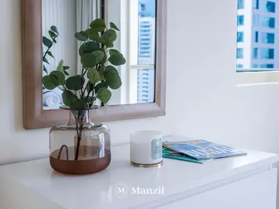 a vase with a plant sitting on a table in front of a mirror at Sea View 2BR in Dubai Marina near Dubai Eye in Dubai