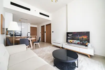 a living room with a white couch and a table at SettlerHomes - JVC Skyline Views - Pool & Gym in Dubai