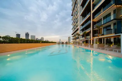 a large swimming pool next to a building at SettlerHomes - JVC Skyline Views - Pool & Gym in Dubai