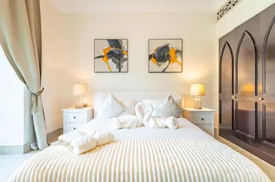 a bedroom with a large white bed with towels on it at Deluxe Arabian-Inspired One Bedroom Stay in Souk Al Bahar Downtown Dubai in Dubai