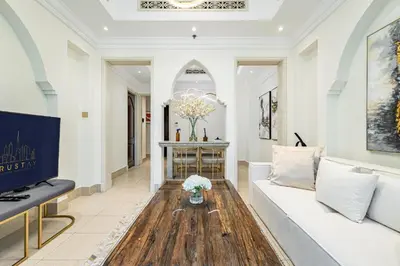 a living room with a white couch and a wooden table at Deluxe Arabian-Inspired One Bedroom Stay in Souk Al Bahar Downtown Dubai in Dubai