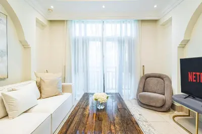a living room with a white couch and a chair at Deluxe Arabian-Inspired One Bedroom Stay in Souk Al Bahar Downtown Dubai in Dubai