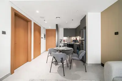 a kitchen and dining room with a table and chairs at SettlerHomes - Chic Cloud B - Pool, Gym & Court in Dubai
