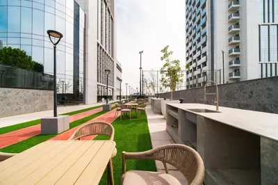 a row of tables and chairs on a balcony with buildings at SettlerHomes - Chic Cloud B - Pool, Gym & Court in Dubai