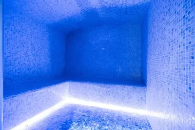 a room with a tub with blue lights in it at SettlerHomes - Chic Cloud B - Pool, Gym & Court in Dubai
