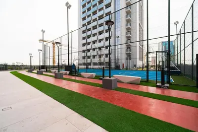 a playground in a building with green and red grass at SettlerHomes - Chic Cloud B - Pool, Gym & Court in Dubai