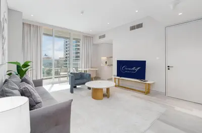 a living room with a couch and a tv at Bright & Modern 1BR in Dubai Marina in Dubai