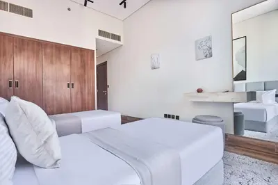 a white bedroom with a white couch and a mirror at Frank Porter - J One Tower in Dubai