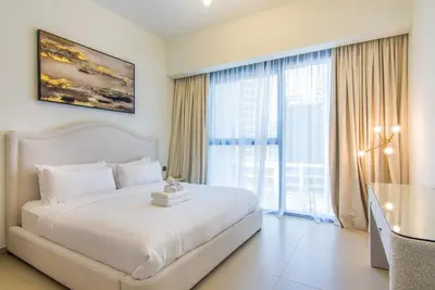 a bedroom with a large bed and a large window at One Bedroom Apartment with Balcony in Act One Act Two, Downtown in Dubai