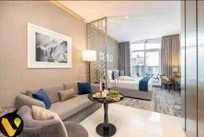 a living room with a couch and a bed at Vogue Business Bay Damac Maison Prive near Burj Khalifa and Dubai Mall, Studio Apartment with Balcony, City and Canal View, Access to all Amenities in Dubai