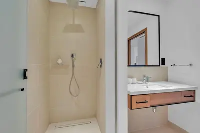 a bathroom with a shower and a sink and a mirror at Full Marina view luxury apartment in Dubai in Dubai