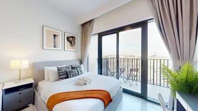 a bedroom with a bed and a balcony at Vacationer l Modern Studio l Community Views l Free Gym, Pool in Dubai