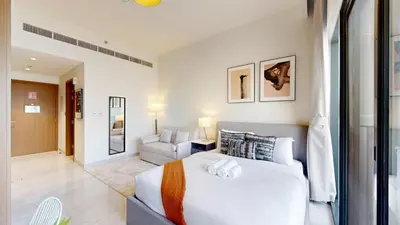 a bedroom with a large white bed and a couch at Vacationer l Modern Studio l Community Views l Free Gym, Pool in Dubai