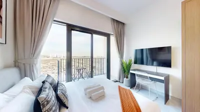a living room with a white couch and a large window at Vacationer l Modern Studio l Community Views l Free Gym, Pool in Dubai