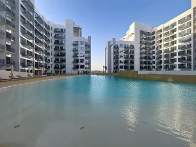 a large pool of water in front of buildings at Vacationer l Modern Studio l Community Views l Free Gym, Pool in Dubai
