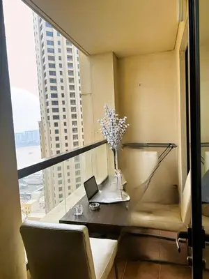 a balcony with a table with flowers and a laptop at ZAH Luxury Holiday Home at JBR,Dubai in Dubai