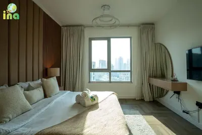 a bedroom with a bed and a large window at INA HOMES - Luxury 2 Bedroom Apartment with Full Burj Khalifa & Fountain Views in Dubai