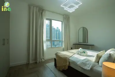 a bedroom with a bed and a large window at INA HOMES - Luxury 2 Bedroom Apartment with Full Burj Khalifa & Fountain Views in Dubai