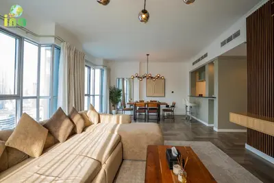 a living room with a couch and a table at INA HOMES - Luxury 2 Bedroom Apartment with Full Burj Khalifa & Fountain Views in Dubai