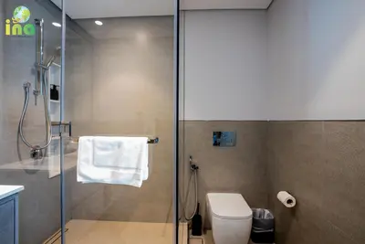 a bathroom with a shower with a toilet and a glass door at INA HOMES - Modren 2 Bedroom Apartment with Full Burj Khalifa View in Dubai