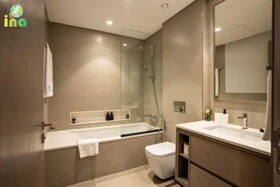 a bathroom with a toilet and a sink and a mirror at INA HOMES - Modren 2 Bedroom Apartment with Full Burj Khalifa View in Dubai