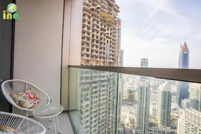 a balcony with chairs and a view of a city at INA HOMES - Modren 2 Bedroom Apartment with Full Burj Khalifa View in Dubai