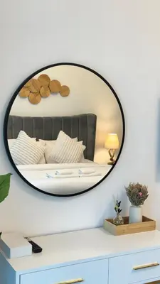 a mirror on a wall above a white dresser at Studio in central location with Balcony nearby Metro in Dubai