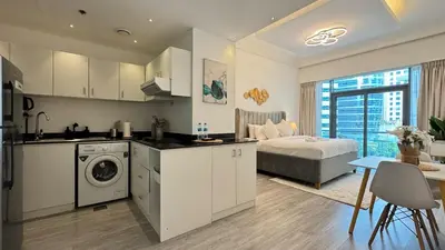 a kitchen and living room with a bed in a room at Studio in central location with Balcony nearby Metro in Dubai