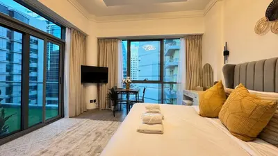 a living room with a bed and a large window at Studio centrally located with a huge private balcony in Dubai
