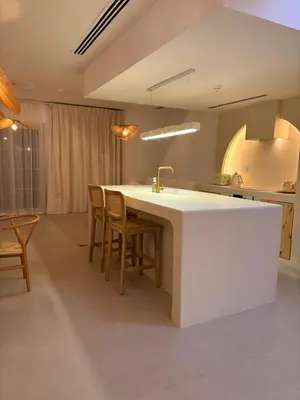 a kitchen with a large white counter and chairs at Dubai Escape Private Pool and Parking in Dubai