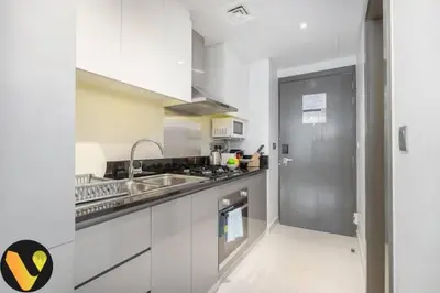 a kitchen with a sink and a stove top oven at Vogue Business Bay Damac Maison Prive near Burj Khalifa and Dubai Mall, Studio Apartment with Balcony, Pool and City View, Access to all Amenities in Dubai