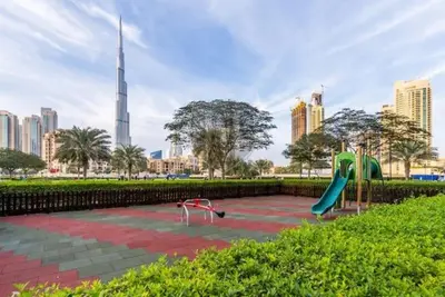 a playground in a park with a tall building at Vogue Business Bay Damac Maison Prive near Burj Khalifa and Dubai Mall, Studio Apartment with Balcony, Pool and City View, Access to all Amenities in Dubai